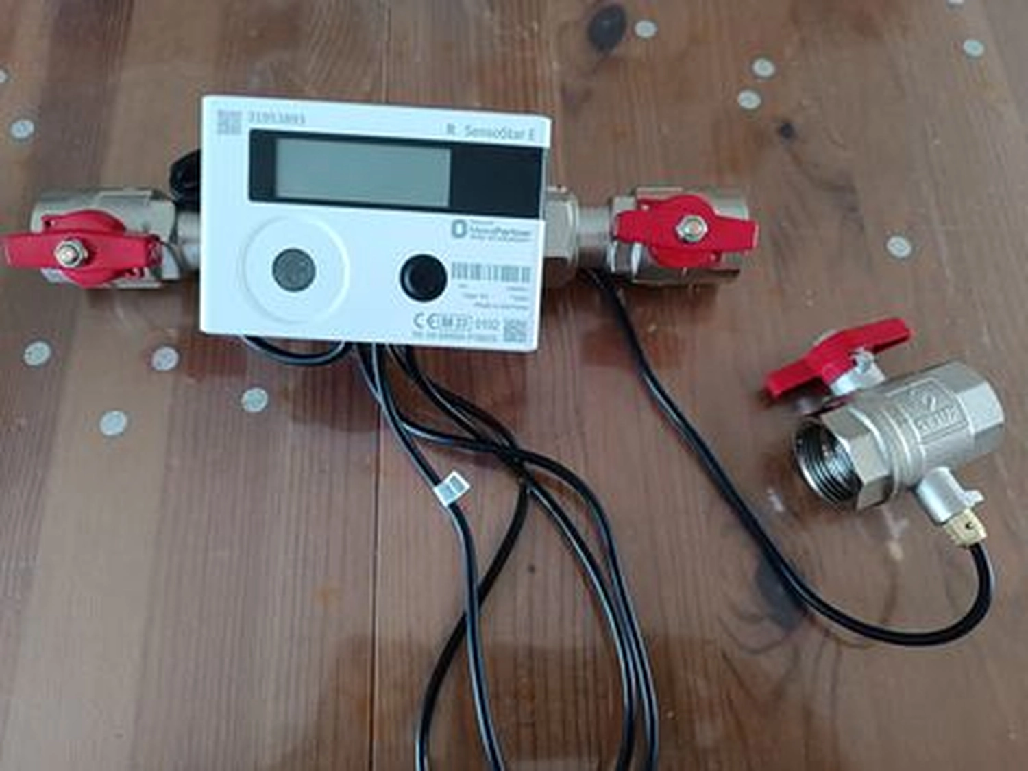 Fair Therm GmbH - Rechtskonforme Abrechnung und Analyse - Ein weißes, rechteckiges elektronisches Gerät mit der Aufschrift „Cengelmann“ und „Sontex“, wahrscheinlich ein Wärme- oder Wasserzähler, mit digitaler Anzeige und unten angeschlossenen Drähten.
